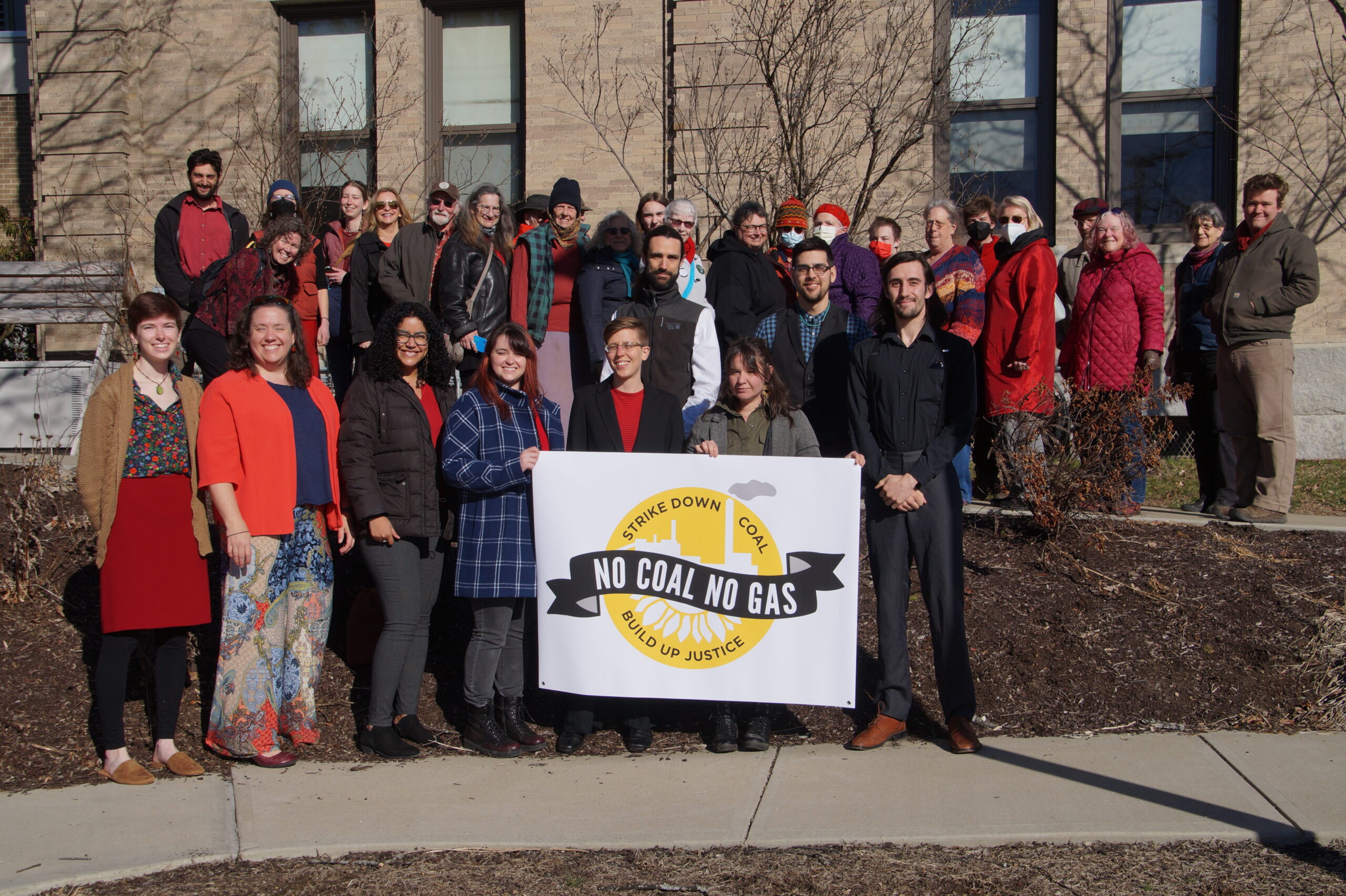 Hooksett Trial defendants and supporters stand with a No Coal No Gas banner in front of the courthouse.